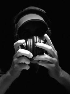 a black and white photo of hands holding large headphones